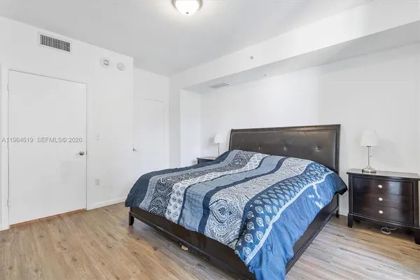 a bedroom with a bed and wooden floor
