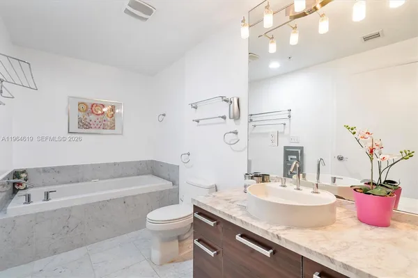 a bathroom with a granite countertop sink a toilet and bathtub
