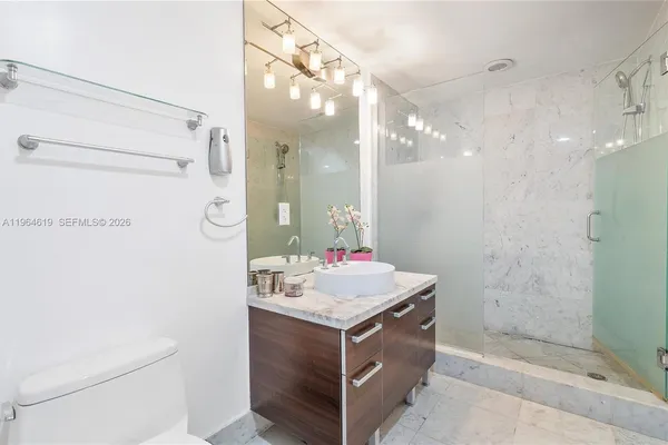 a bathroom with a sink mirror vanity and toilet