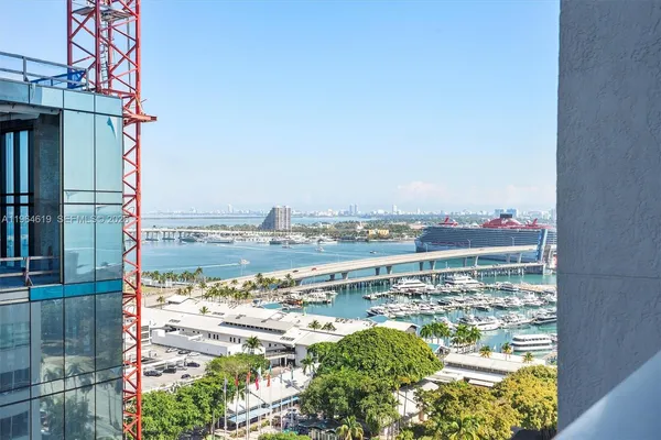 a view of a hallway with wooden floor and a bathroom
