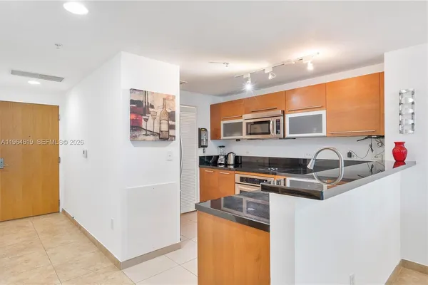 a kitchen with stainless steel appliances granite countertop a refrigerator and a sink