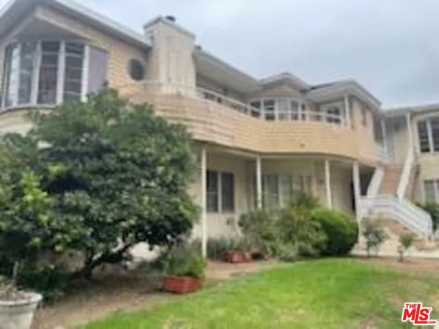 a front view of a house with a yard and trees