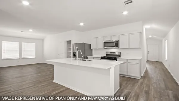 a kitchen with stainless steel appliances a stove top oven a sink a refrigerator with wooden floor and cabinets