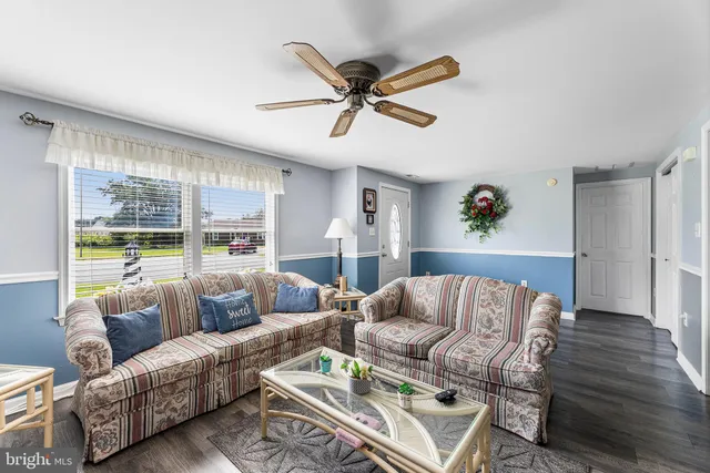 a living room with furniture ceiling fan and a rug