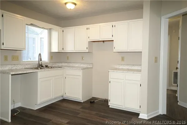 a kitchen with white cabinets and white appliances