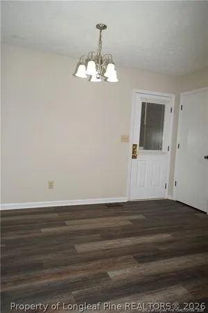 a view of a room with wooden floor and ceiling fan