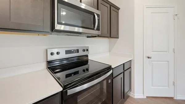 a kitchen with a sink and a stove top oven with wooden floor