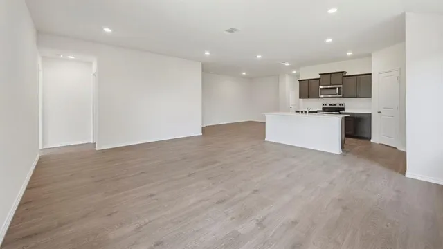 a large kitchen with stainless steel appliances kitchen island a large counter top and a wooden floors