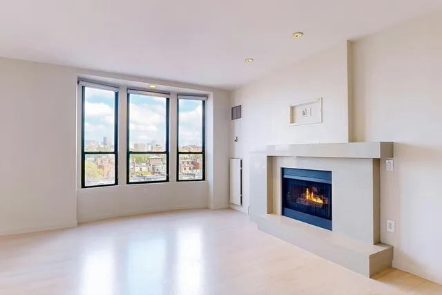 a view of an empty room with a window and fireplace