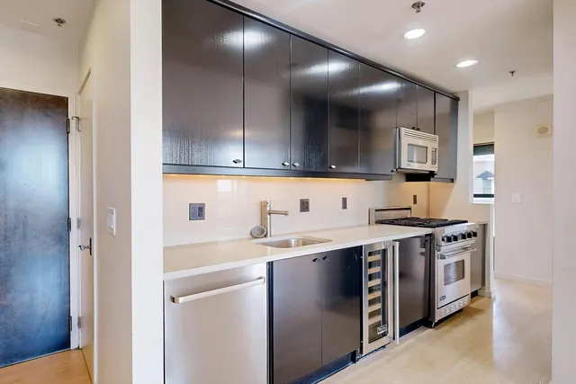a kitchen with stainless steel appliances granite countertop a sink and a stove