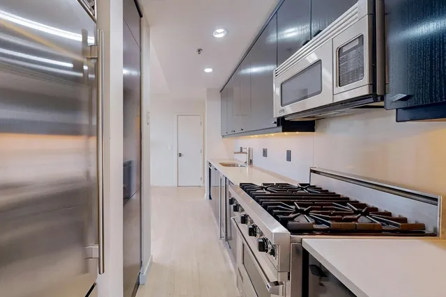 a kitchen with stainless steel appliances granite countertop a stove and a refrigerator