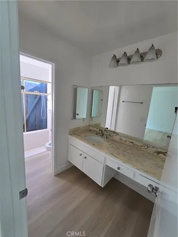 a bathroom with a granite countertop sink and a mirror