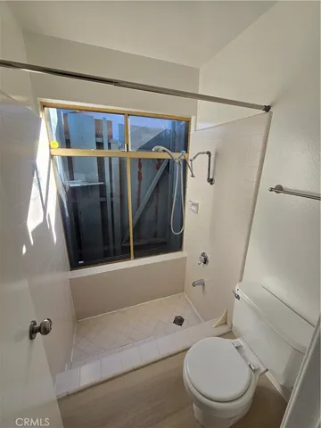 a bathroom with a shower a toilet and a shower
