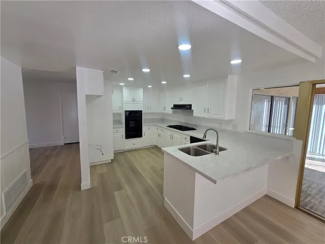 a kitchen with sink cabinets and wooden floor