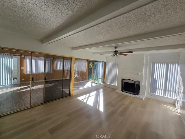 wooden floor fireplace and windows in an empty room
