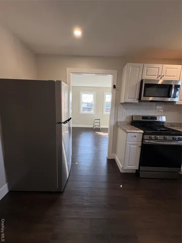 a kitchen with stainless steel appliances granite countertop a refrigerator and a stove