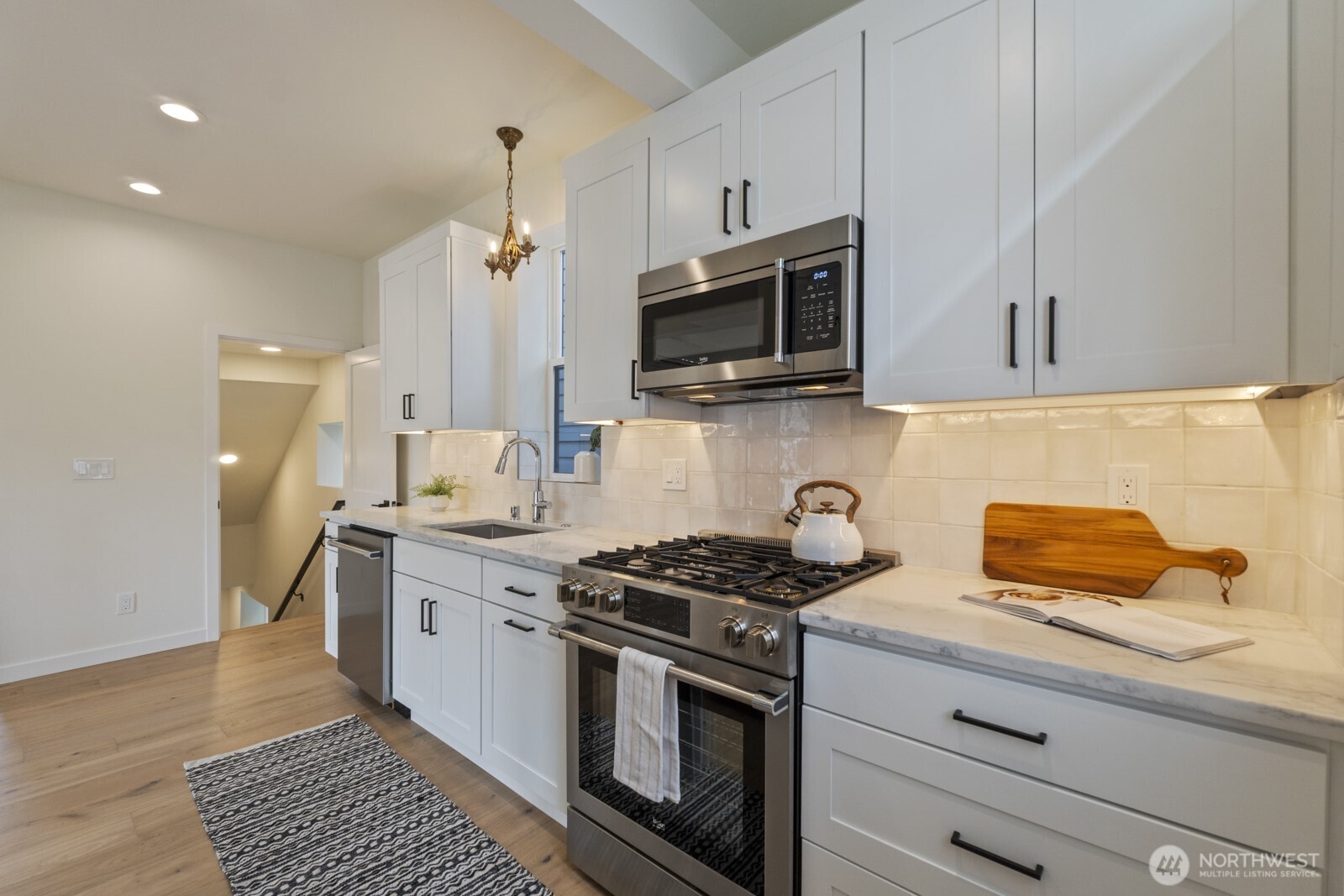 101 North 51st Street Seattle, WA 98103 - Photo 11 of 38 a kitchen with stainless steel appliances a stove a microwave and cabinets