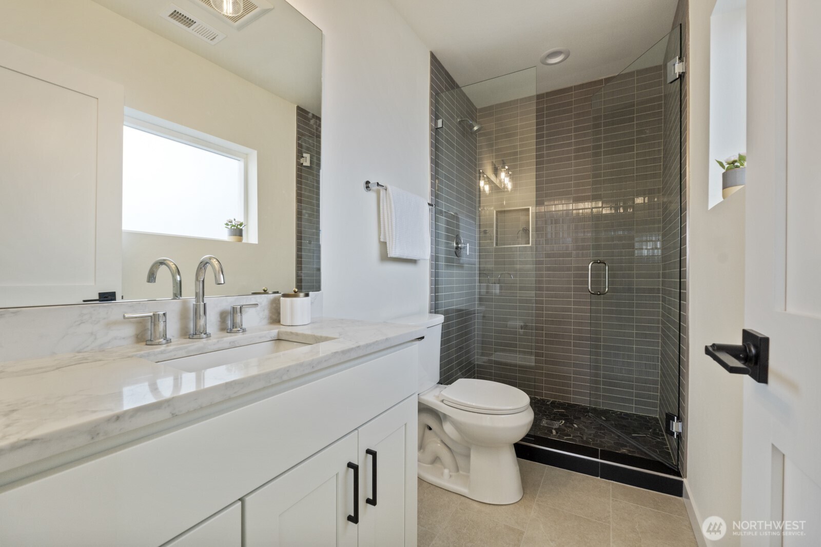 101 North 51st Street Seattle, WA 98103 - Photo 24 of 38 a bathroom with a granite countertop toilet a sink a mirror and shower
