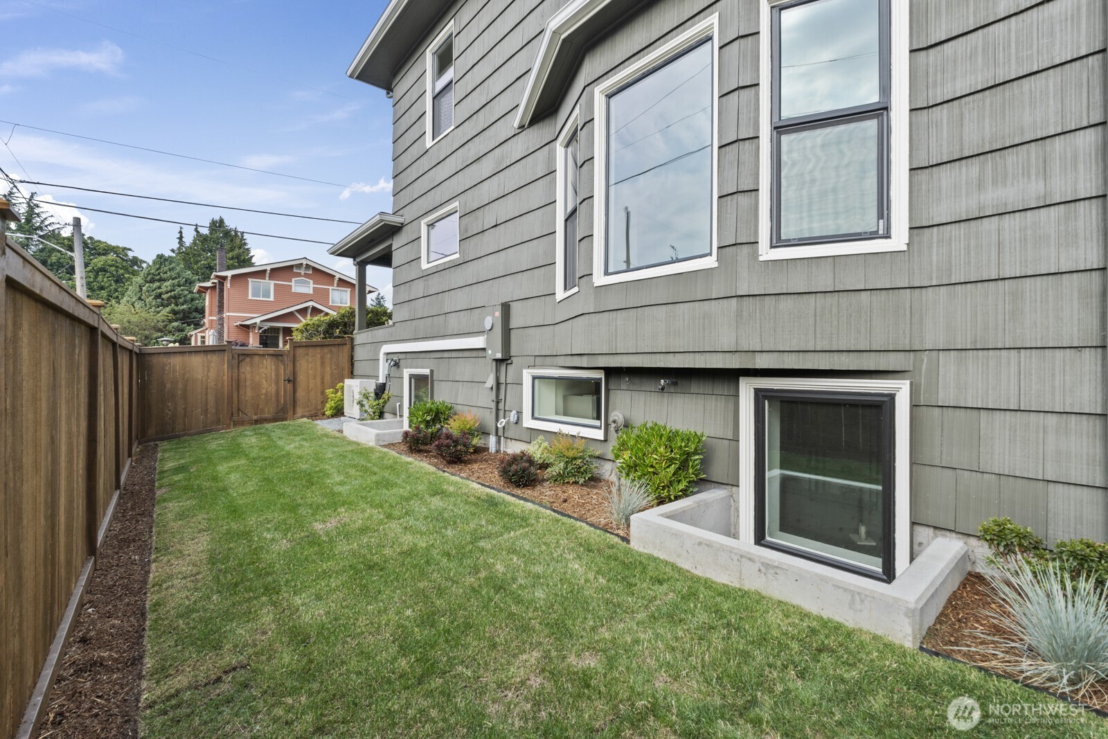 101 North 51st Street Seattle, WA 98103 - Photo 30 of 38 a view of a house with brick walls and a yard with plants