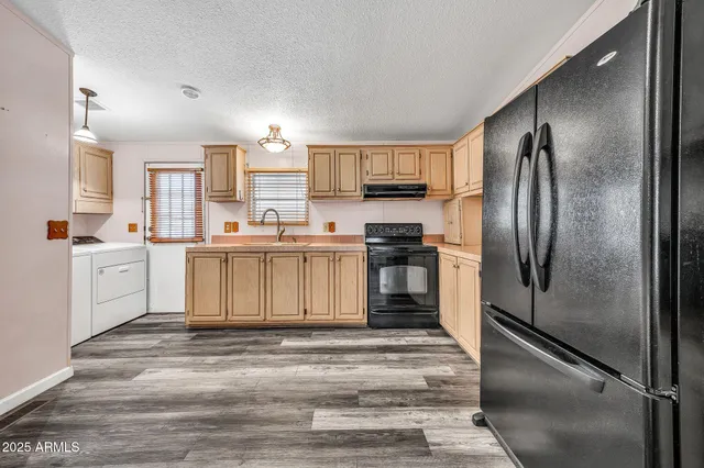 a kitchen with stainless steel appliances granite countertop a sink dishwasher a stove and a microwave oven with cabinets