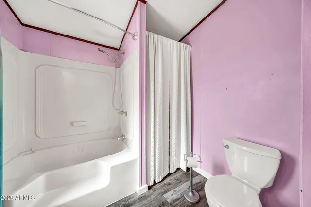 a kitchen with stainless steel appliances kitchen island granite countertop a refrigerator a sink dishwasher a stove and a dining table with wooden floor