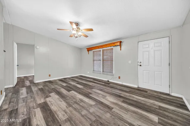 a view of a livingroom with wooden floor and a ceiling fan