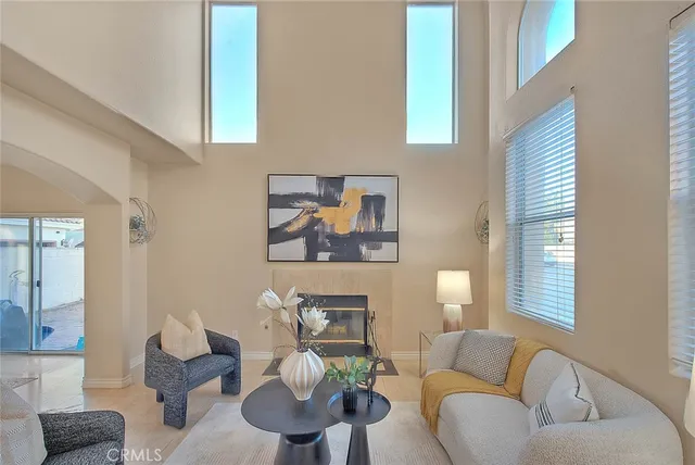 a living room with furniture a fireplace and a potted plant