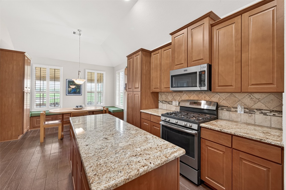 2719 Intrepid Trail Rosenberg, TX 77471 - Photo 2 of 50 a kitchen with stainless steel appliances granite countertop a stove top oven a sink dishwasher and microwave with wooden floor