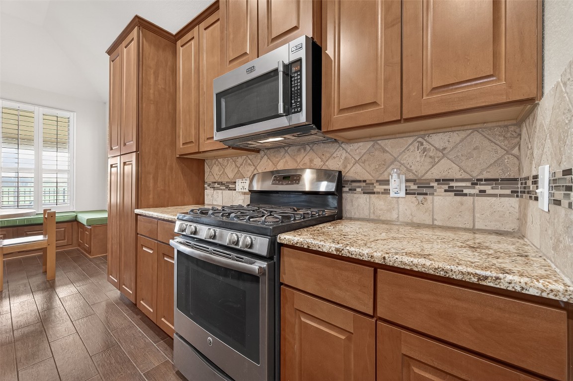 2719 Intrepid Trail Rosenberg, TX 77471 - Photo 23 of 50 a kitchen with stainless steel appliances granite countertop a stove microwave and cabinets