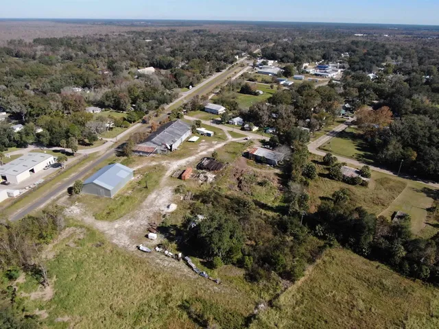 an aerial view of residential houses with outdoor space and trees