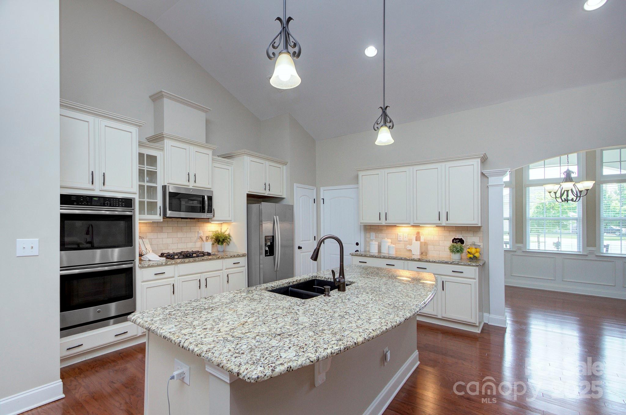 317 Annatto Way Tega Cay, SC 29708 - Photo 13 of 44 a kitchen with stainless steel appliances granite countertop a sink stove and refrigerator