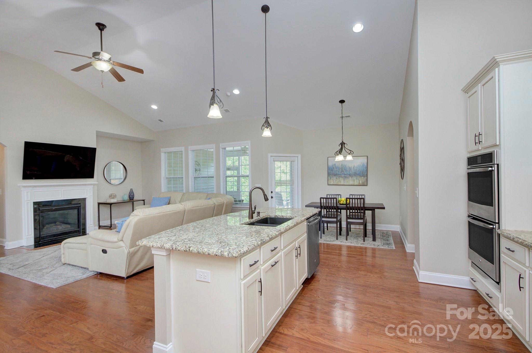 317 Annatto Way Tega Cay, SC 29708 - Photo 15 of 44 a spacious kitchen with stainless steel appliances granite countertop a stove and a sink with living room