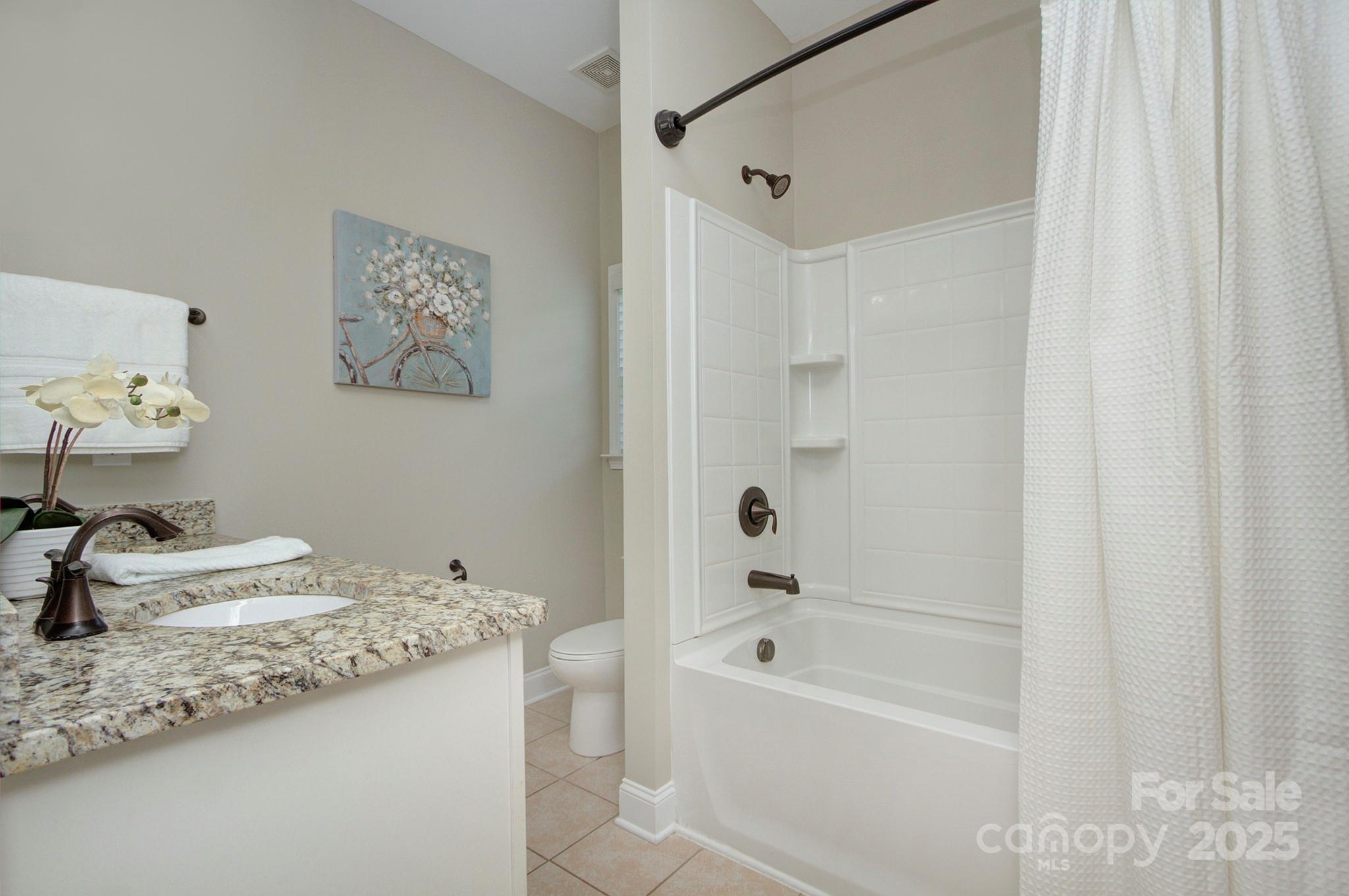 317 Annatto Way Tega Cay, SC 29708 - Photo 26 of 44 a bathroom with a granite countertop sink a toilet and bathtub