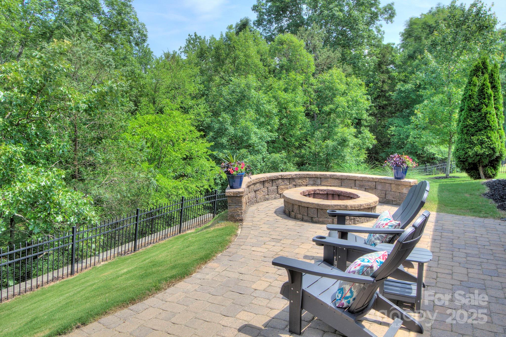 317 Annatto Way Tega Cay, SC 29708 - Photo 30 of 44 a view of a patio with table and chairs with wooden fence and plants