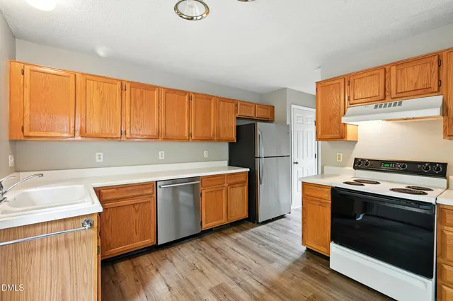 a kitchen with wooden cabinets and a stove top oven