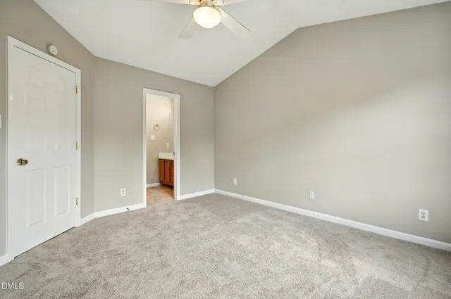 an empty room with an entryway and fan