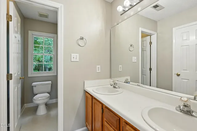 a bathroom with a granite countertop sink a toilet and a large mirror