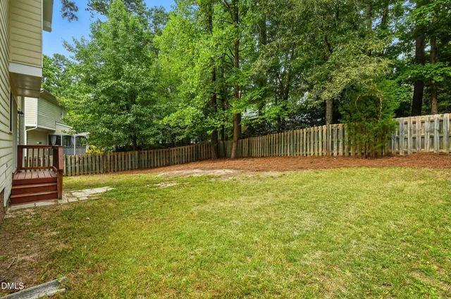 a view of a backyard with fence and plants