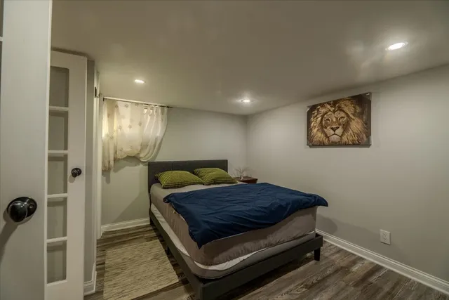 a large bedroom with a bed and a large mirror on the dresser
