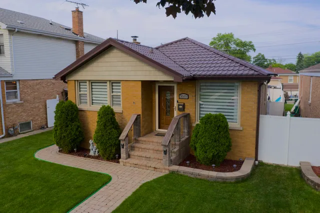 a view of a house with backyard and a tree