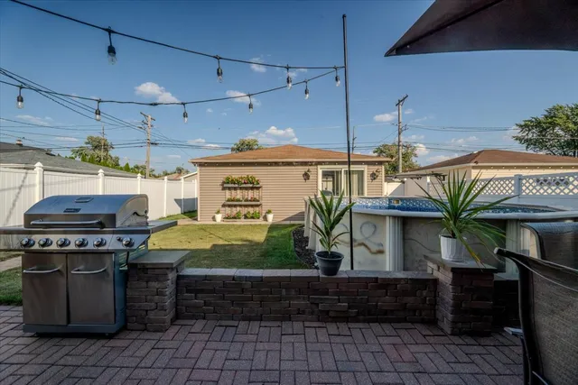 a open kitchen with stainless steel appliances granite countertop a stove a sink dishwasher and a dining table with the garden view