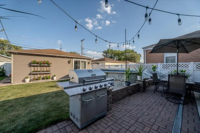 a view of a patio with table and chairs under an umbrella