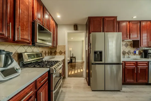 a kitchen with stainless steel appliances granite countertop a refrigerator stove and a sink