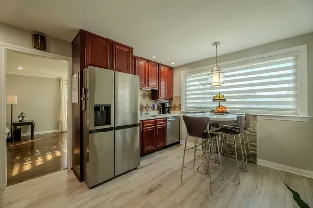 a kitchen with a refrigerator a table and chairs in it