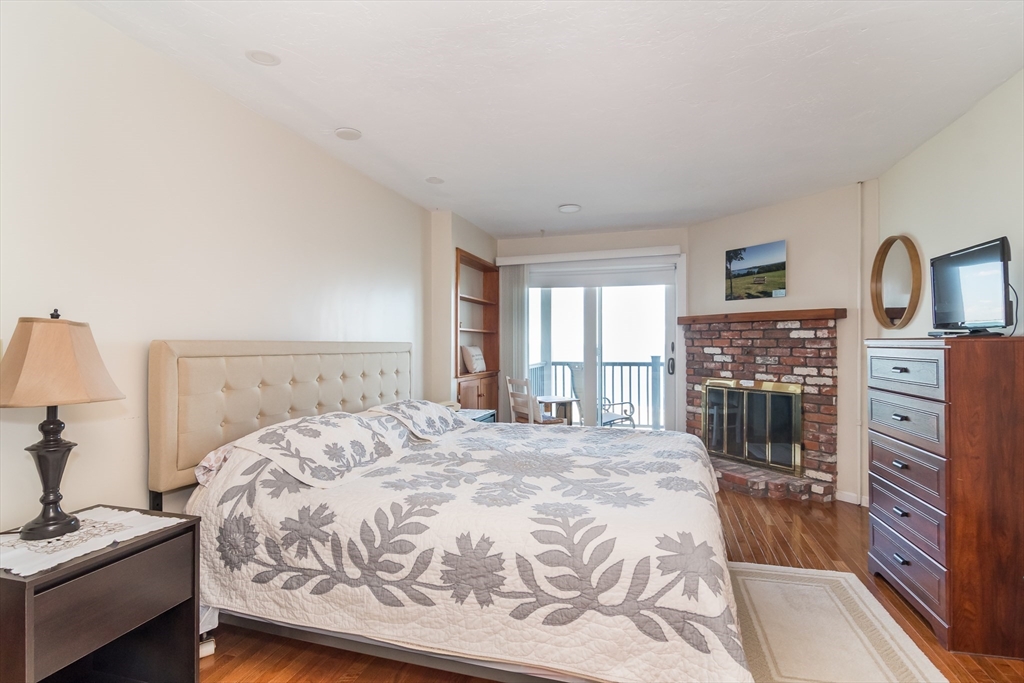 22 Oceanside Drive, Unit 22 Hull, MA 02045 - Photo 6 of 7 a spacious bedroom with a bed and a dresser in it
