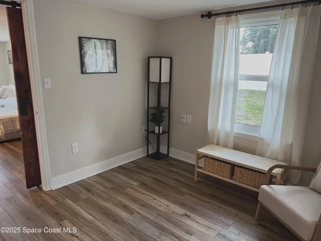 a view of room with window and wooden floor