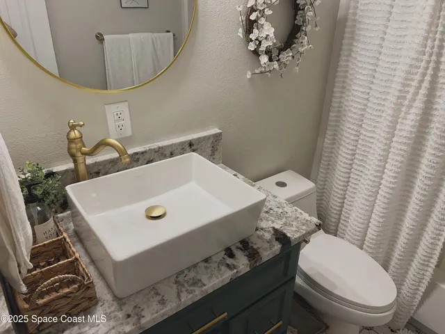 a bathroom with a sink toilet and mirror