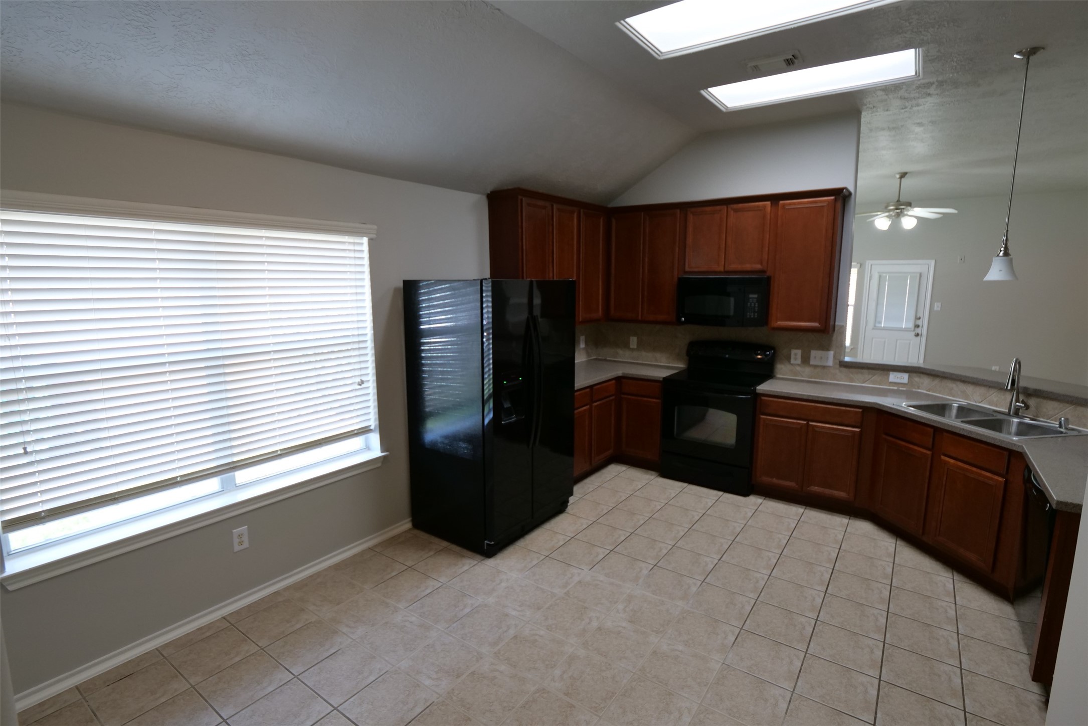 5414 Trammel Drive Spring, TX 77388 - Photo 5 of 28 a kitchen with a refrigerator a stove a sink and a window