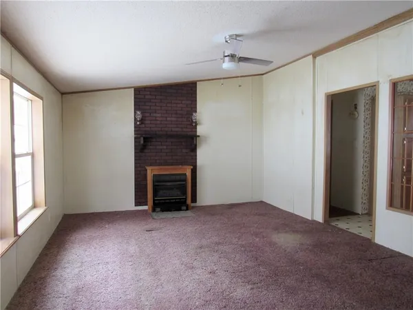 a view of an empty room with a fireplace and a window
