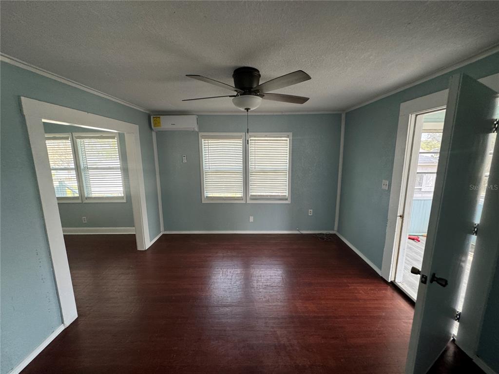 348 South Central Avenue, Unit U Umatilla, FL 32784 - Photo 4 of 13 an empty room with wooden floor and windows